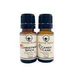 Two small brown bottles with black caps, labeled as 'Christmas Spice' and 'Candy Cane' essential oil blends from moon haven.